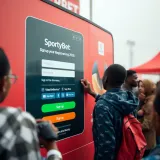 Mobile device displaying SportyBet registration form with Nigeria flag in background